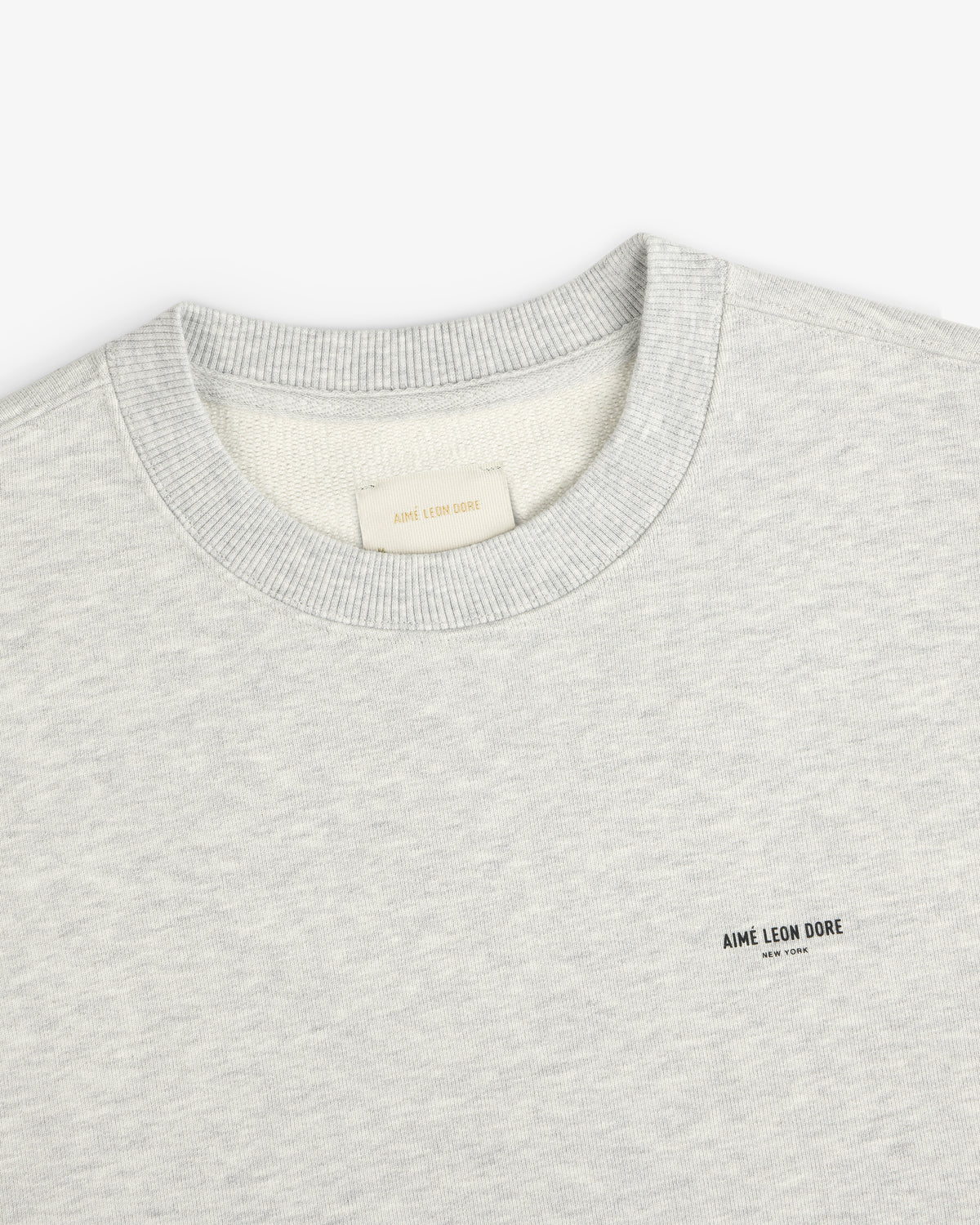 Light gray Micro Logo Crewneck Sweatshirt with chest AIMÉ LEON DORE text and visible neck tag.