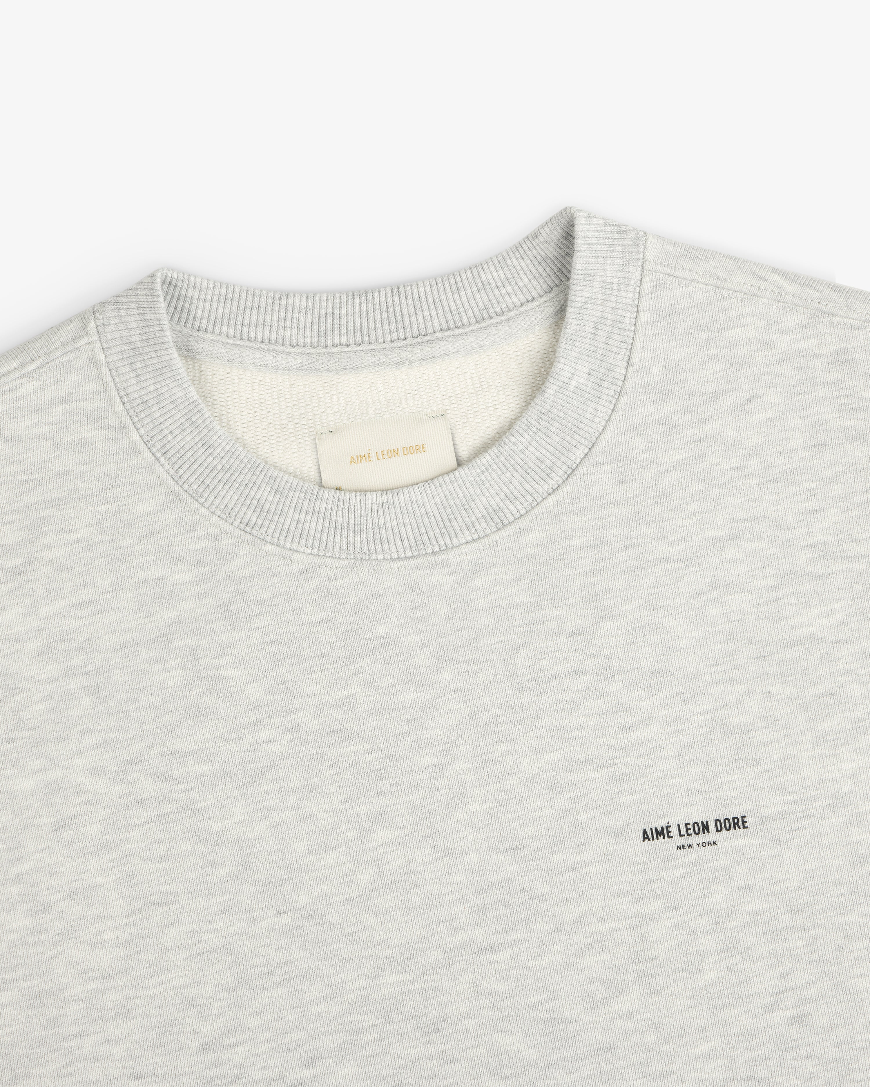 Light gray Micro Logo Crewneck Sweatshirt with chest AIMÉ LEON DORE text and visible neck tag.