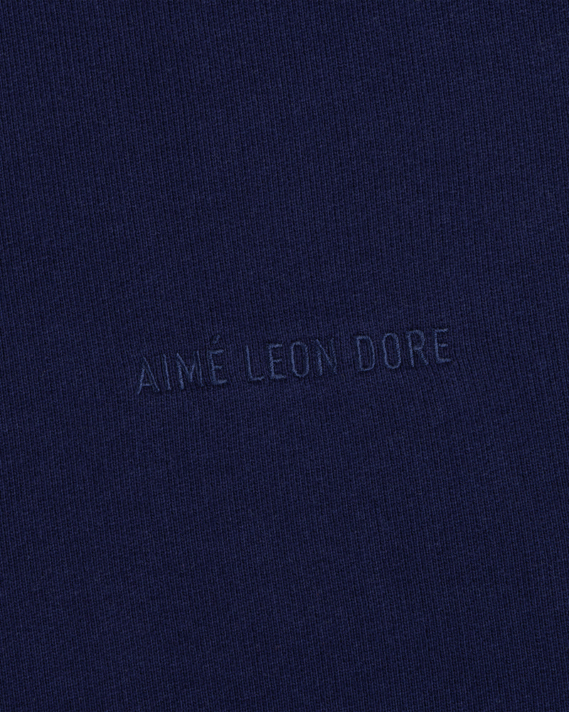 Closeup of navy fabric with Tonal Logo Crewneck Sweatshirt text subtly embossed in matching blue at the center.
