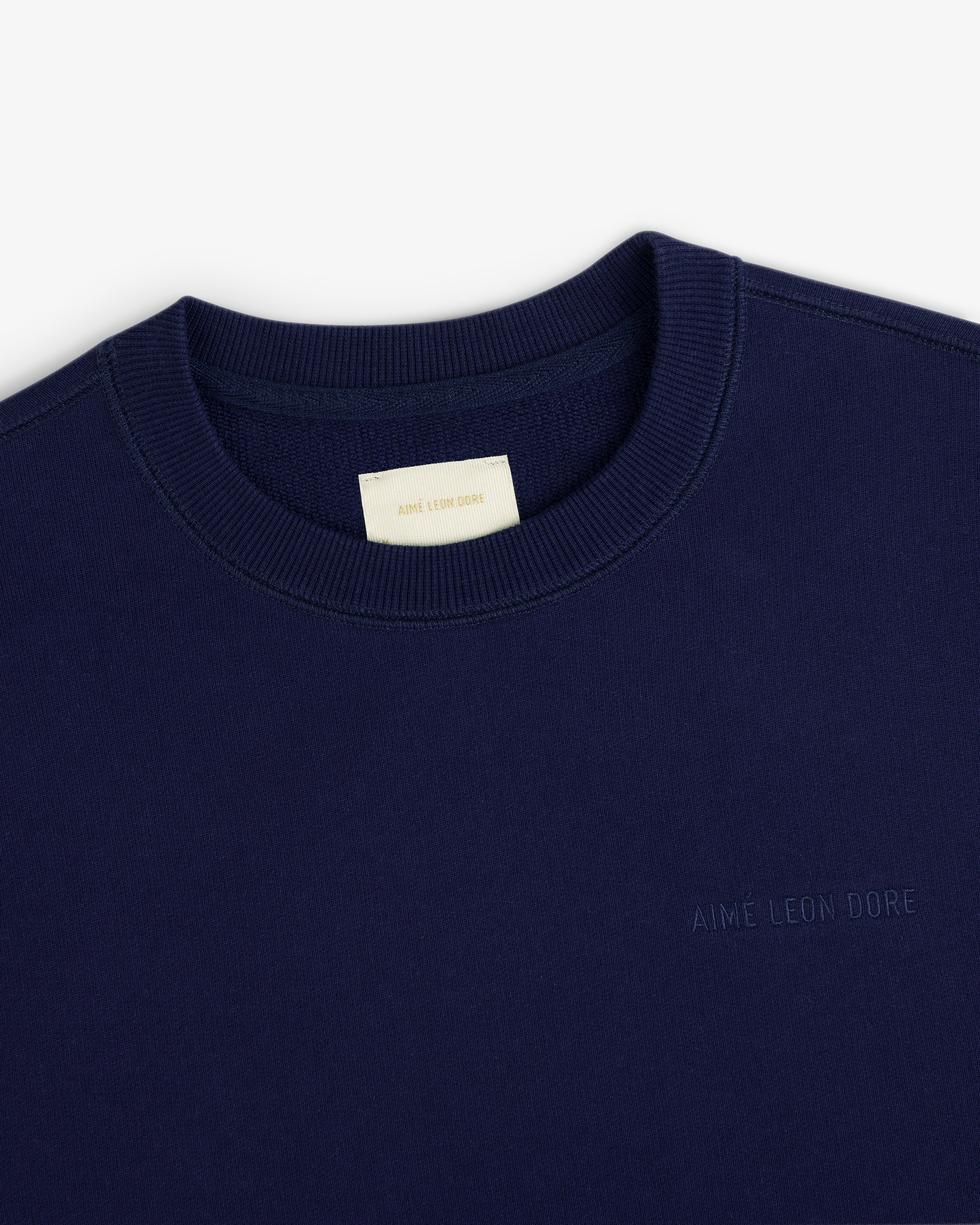 Navy Tonal Logo Crewneck Sweatshirt with AIMÉ LEON DORE chest embroidery and a cream neck tag.