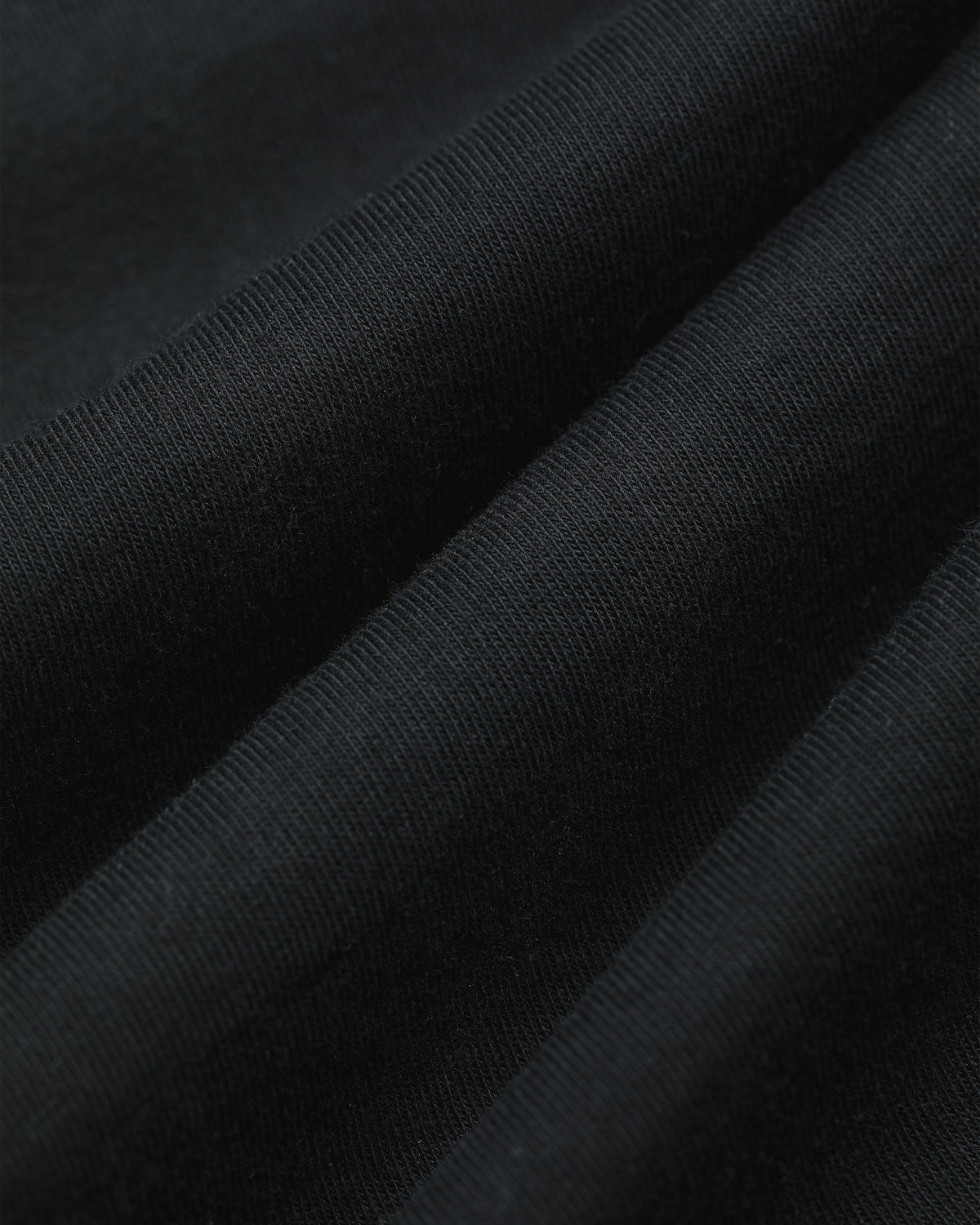Close-up of T-Shirt 3-Pack in black, showing soft diagonal folds and visible knit texture.