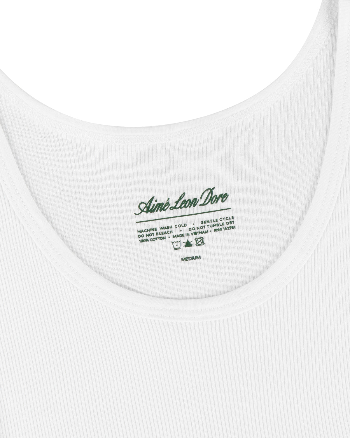 Close-up of a white Tank Top 3-Pack with Aimé Leon Dore and care instructions printed inside the collar in green.