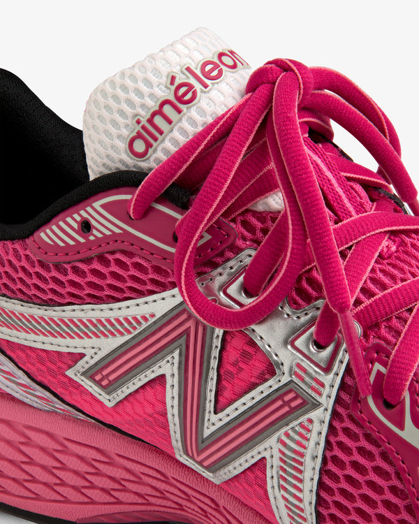 Close-up of a pink ALD / New Balance 860v2 sneaker with silver accents and pink laces.