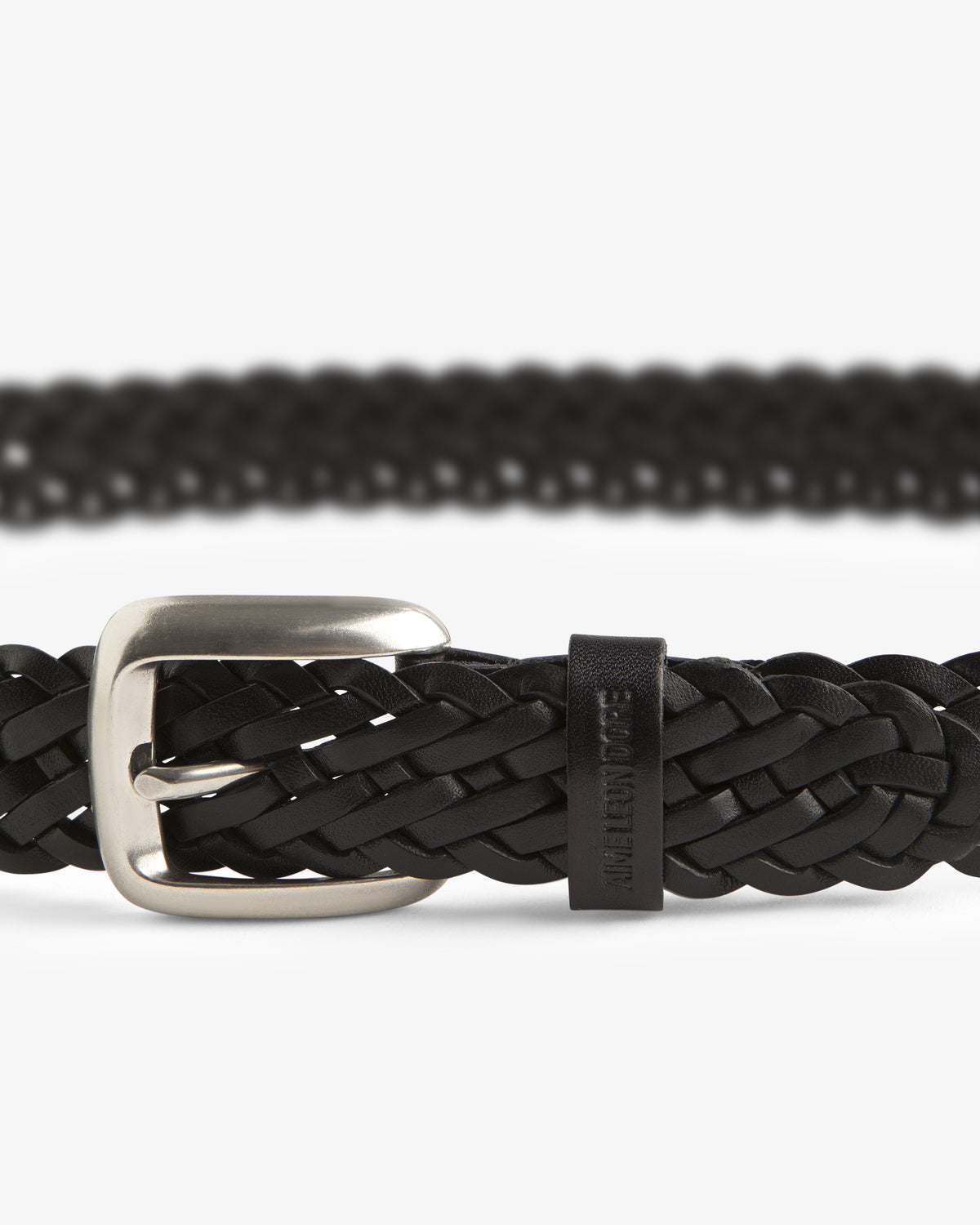 Close-up of the Braided Leather Belt in black with a silver buckle, shown against a white background.