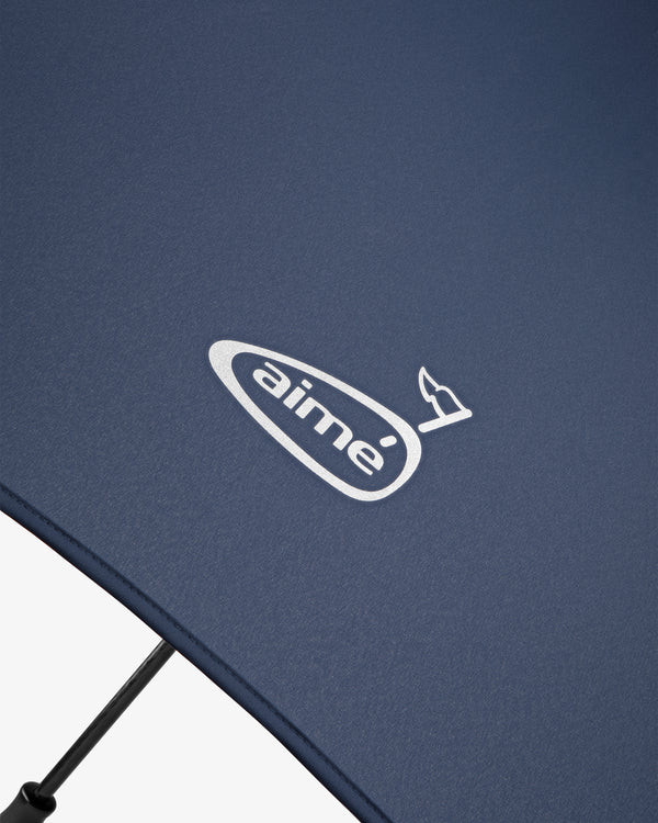 Close-up of a Women's Dress Test featuring a navy blue fabric with the white aimeé logo and a small bird graphic.
