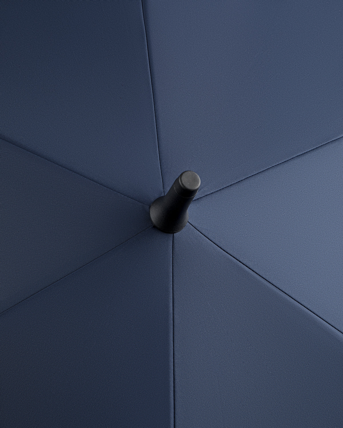 Close-up of the top center of the ALD Golf Spectator Umbrella, highlighting navy panels and black cap.