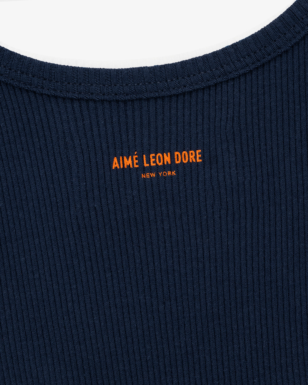 Close-up of a navy Mets Tank Top with AIMÉ LEON DORE NEW YORK in orange text below the collar.
