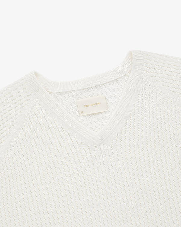 Pointelle Knit Sweater with ribbed V-neck and delicate textured pattern, photographed from above on plain background.