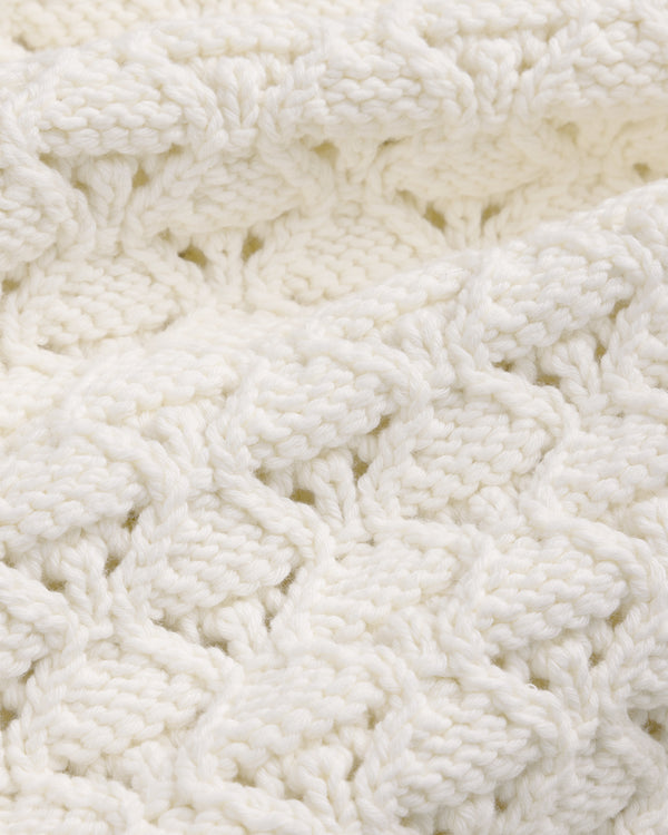 Close-up of Eyelet Knit Crewneck Sweater in white, featuring a soft, textured pattern and intertwined yarn.