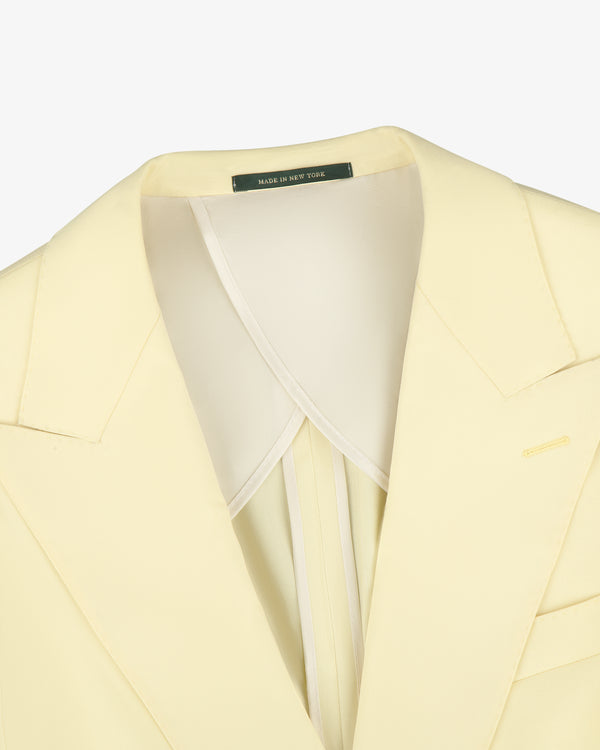 Close-up of Single-Breasted Peak Lapel Suit Jacket in pale yellow with a Made in New York label inside the collar.