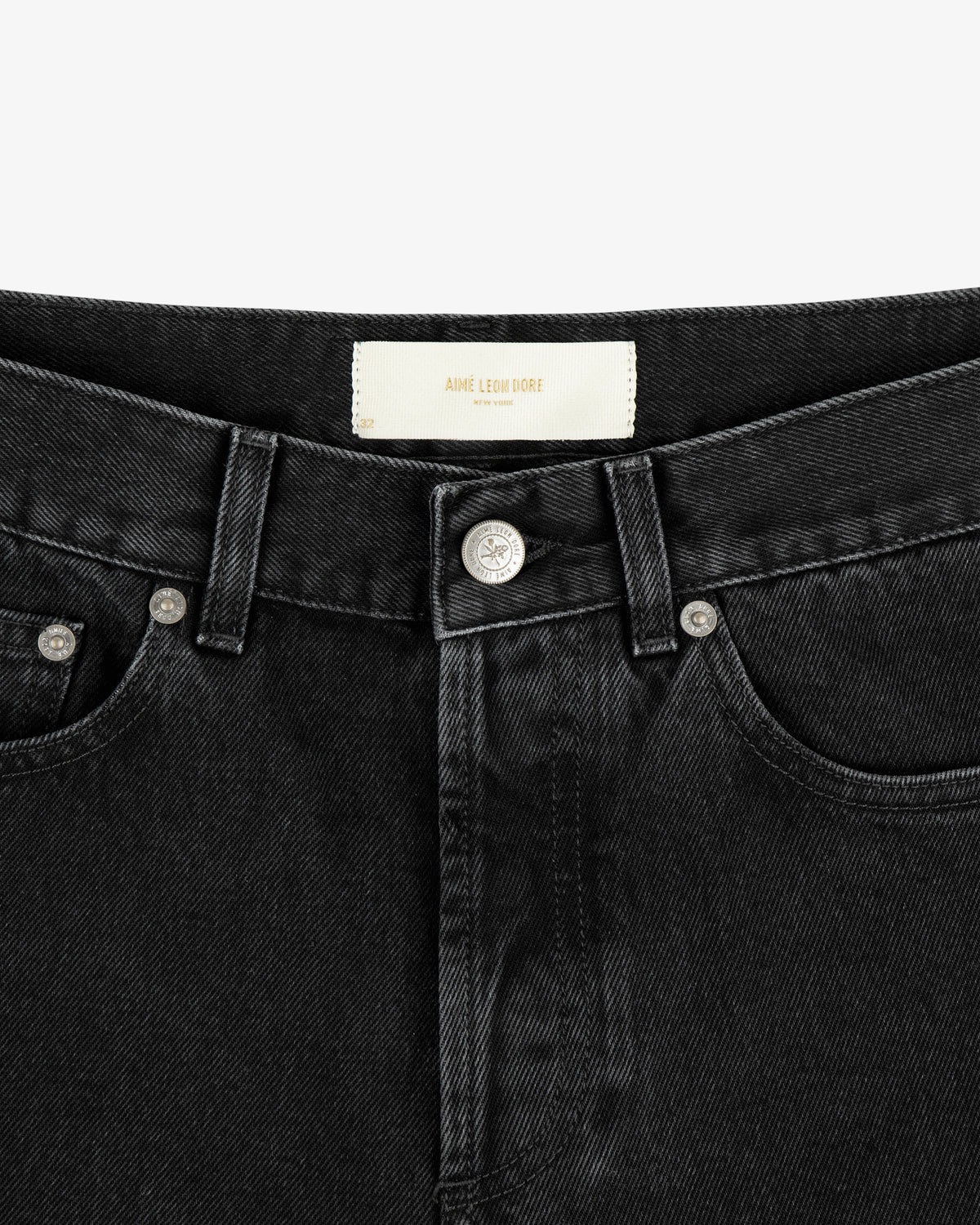 Close-up of the ALD Straight Fit Denim waistband and button, featuring silver rivets and a white inner label.