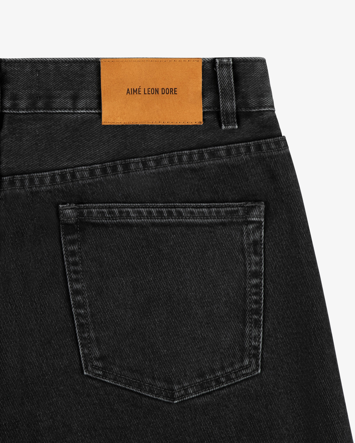 Close-up of ALD Straight Fit Denim in black, featuring a brown AIMÉ LEON DORE patch above the back pocket.