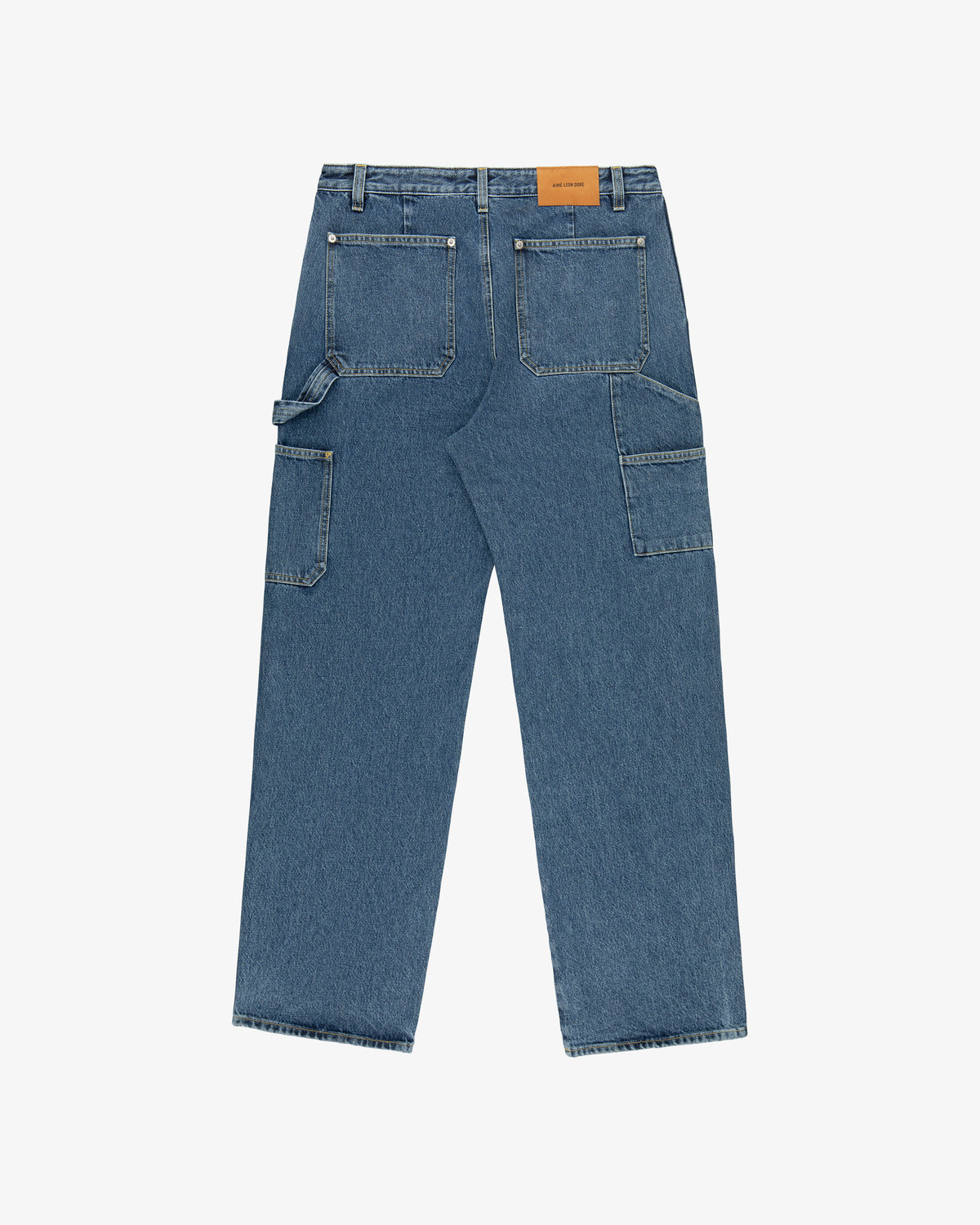 Back view of Denim Carpenter Pant in blue with large pockets, side loops, and a brown leather waistband patch.