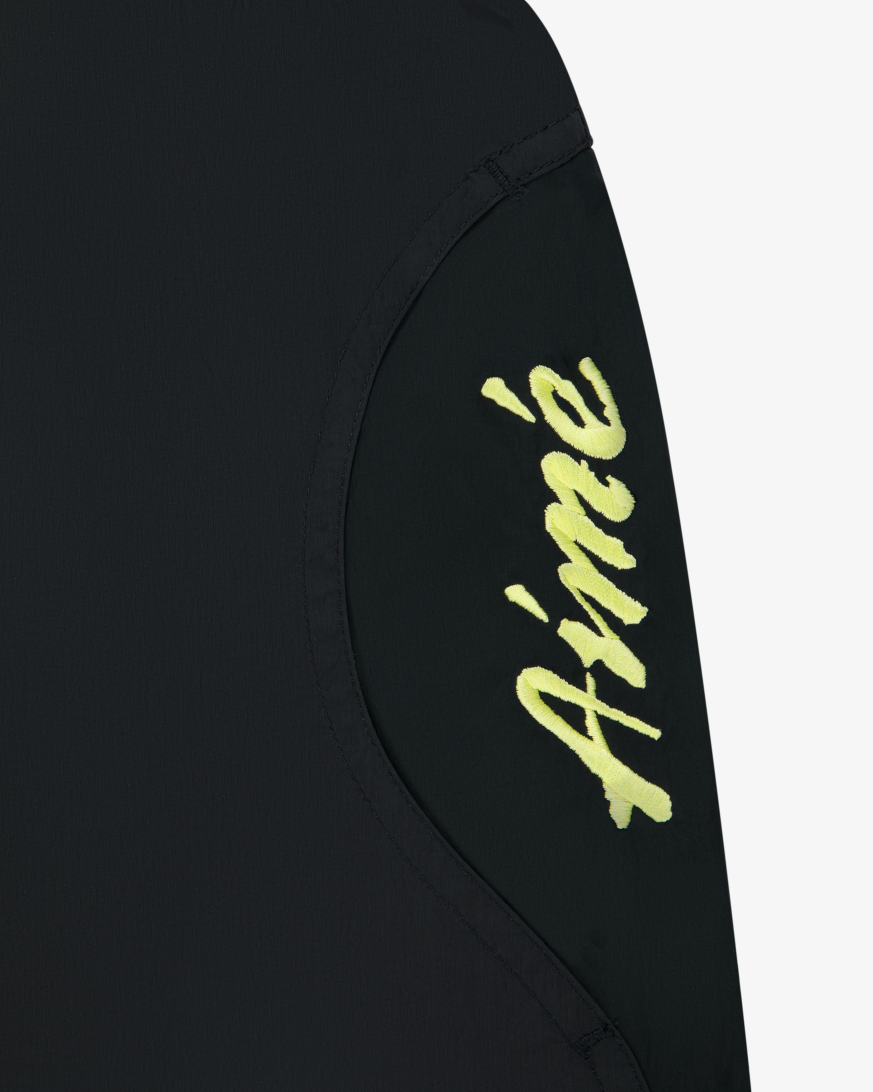 Paneled Sport Short in black with yellow Aimé script on a curved panel, shown against a white background.