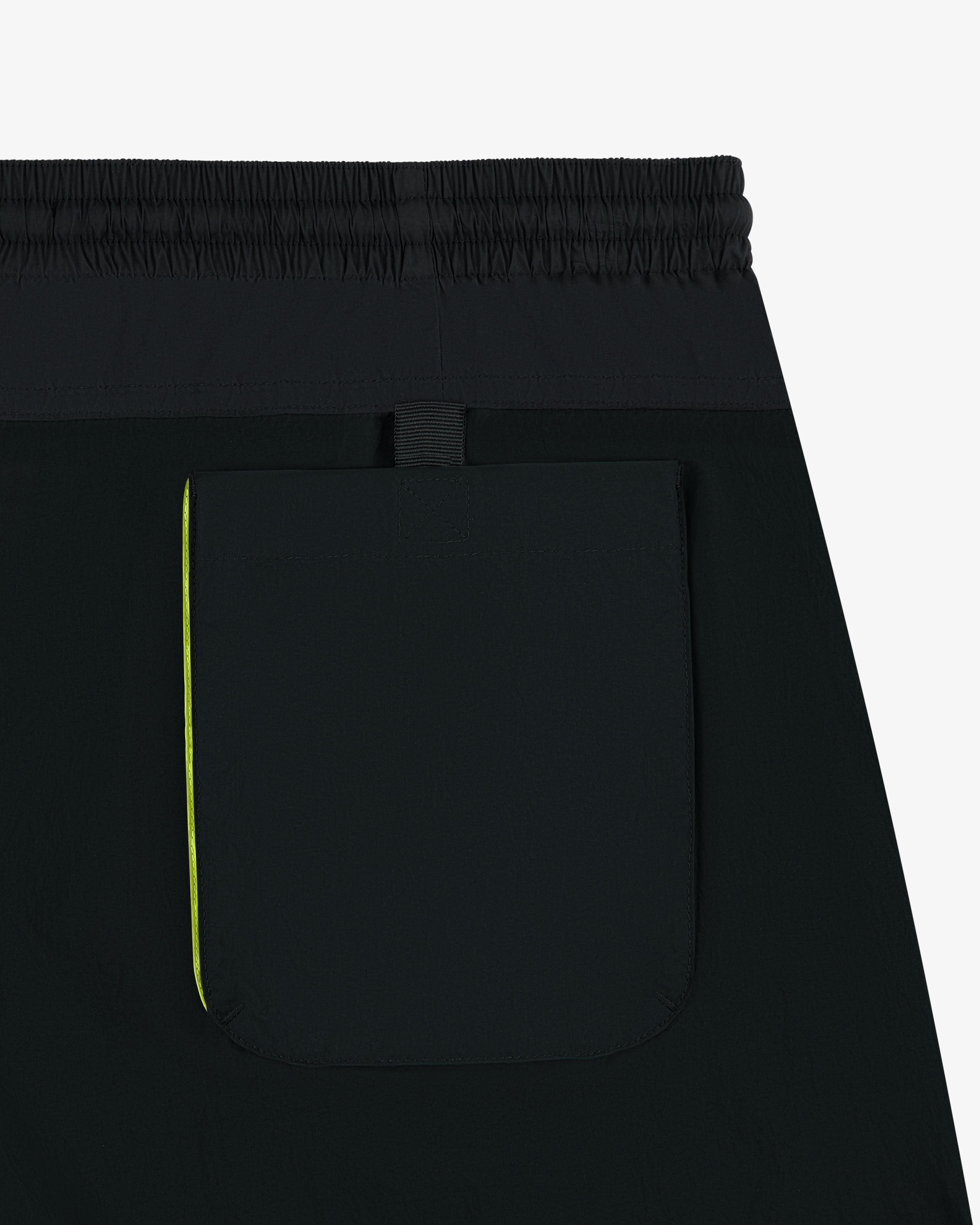 Close-up of Paneled Sport Short in black, featuring an elastic waistband and a back pocket with a yellow stripe.