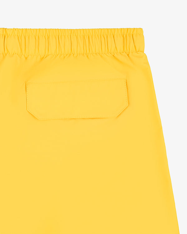 Close-up of Offshore Swim Short in yellow, featuring an elastic waistband and a single flap back pocket.