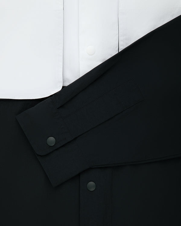 Colorblock Sport Shirt: black sleeve over white front with black snap buttons. Minimalist, high-contrast look.