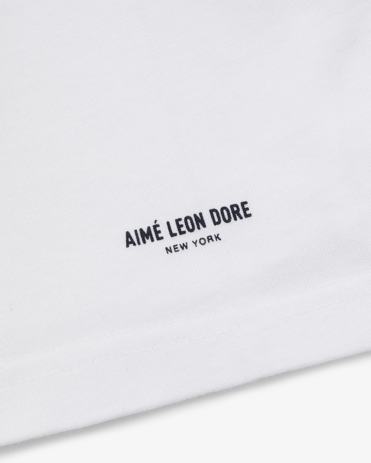 Close-up of the Yankees Chainstitch Pocket Tee, featuring AIMÉ LEON DORE NEW YORK printed in black near the bottom.