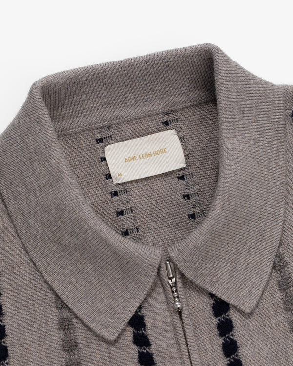 Close-up of a gray Jacquard Stripe Polo Cardigan featuring a zipper and visible AMI ALEXANDRE MATTIUSSI label inside.