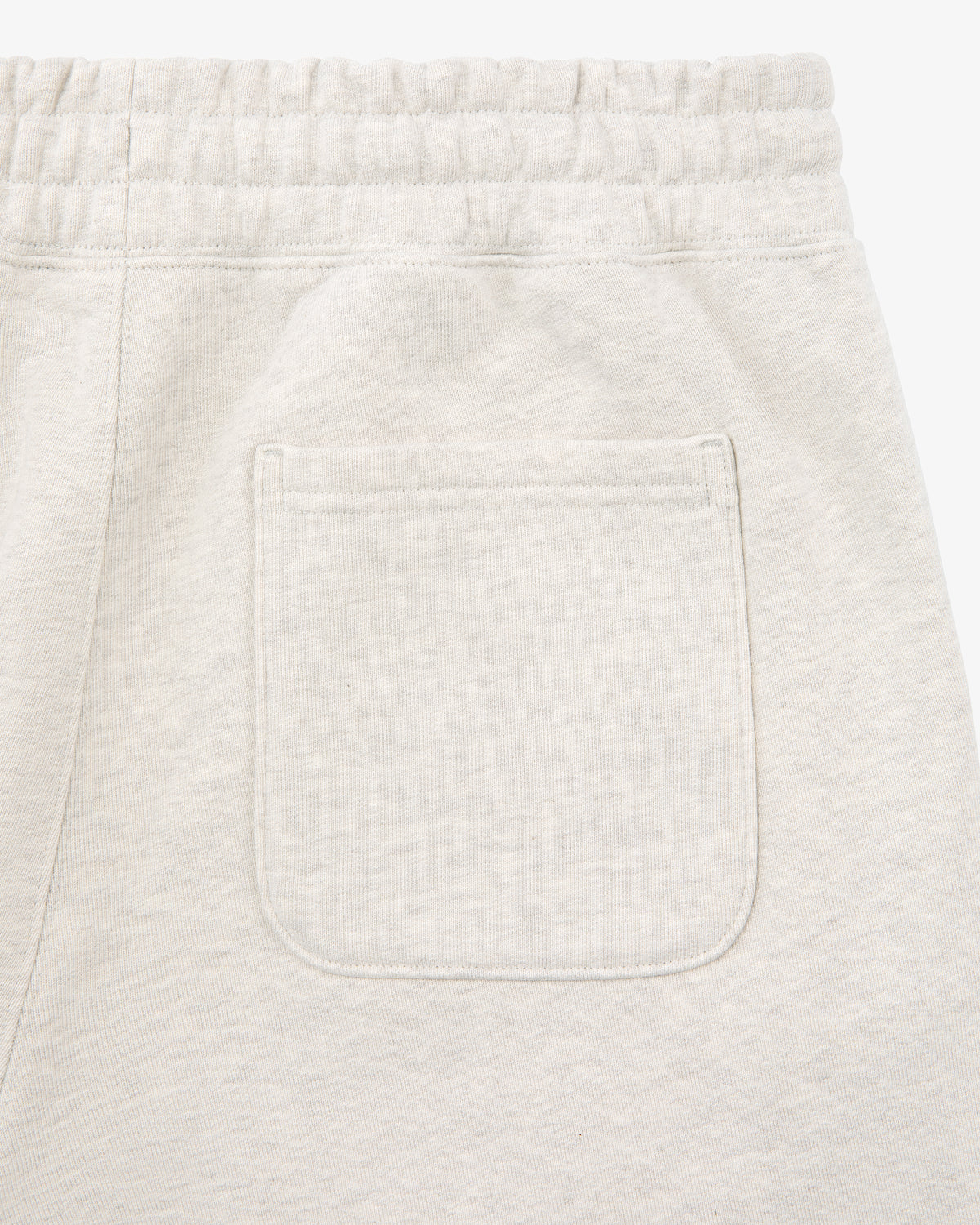 Close-up of the back pocket and waistband of Tonal Logo Sweatpants in light beige, made from soft, textured fabric.