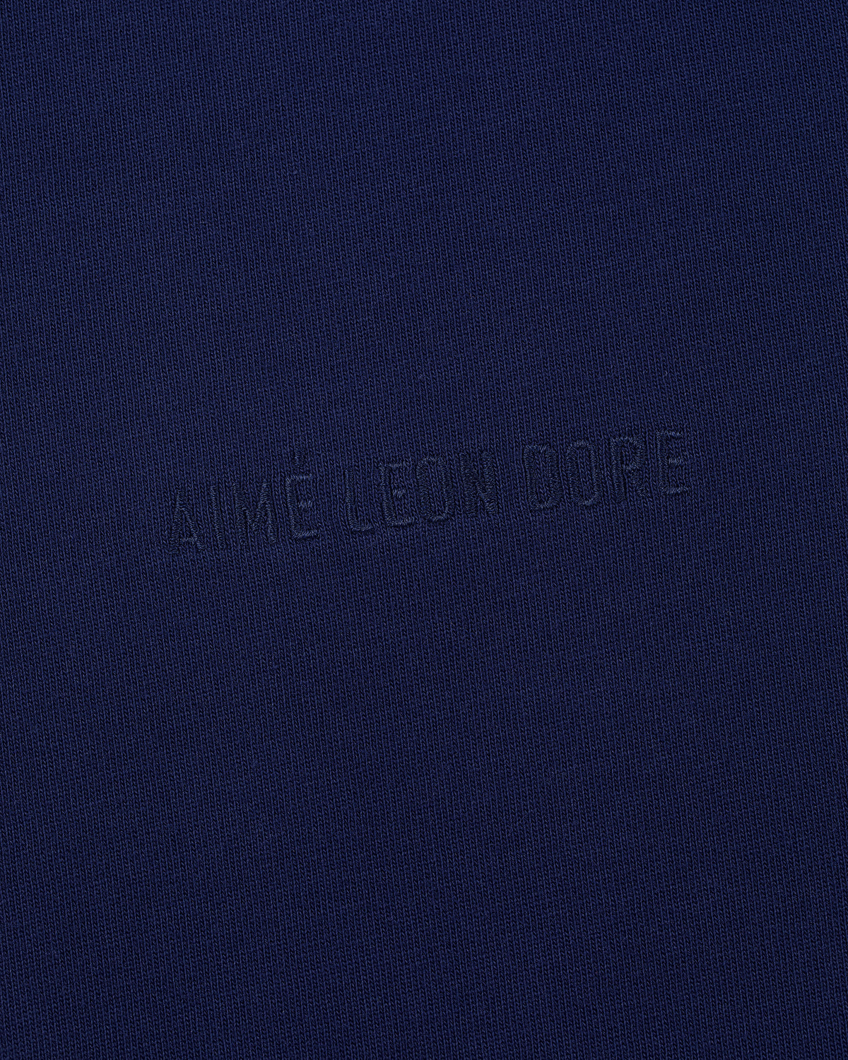 Navy Long-Sleeve Tonal Logo Tee with AIMÉ LEON DORE embossed subtly across the center.