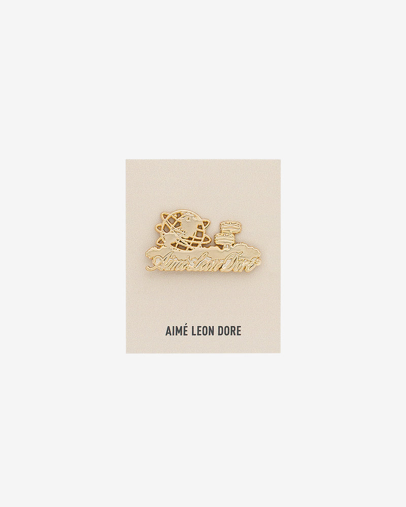 ALD Pin featuring a globe, mailbox, and cursive Aimé Leon Dore on a white AIMÉ LEON DORE card.