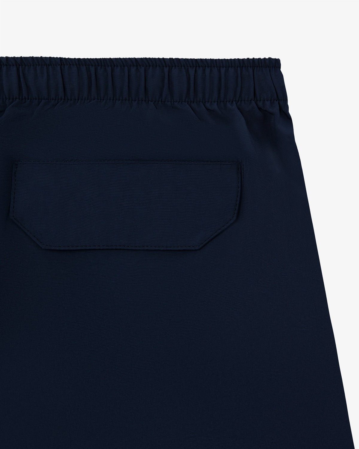 Close-up of the Core Nylon Short in navy blue with an elastic waistband and a back flap pocket.