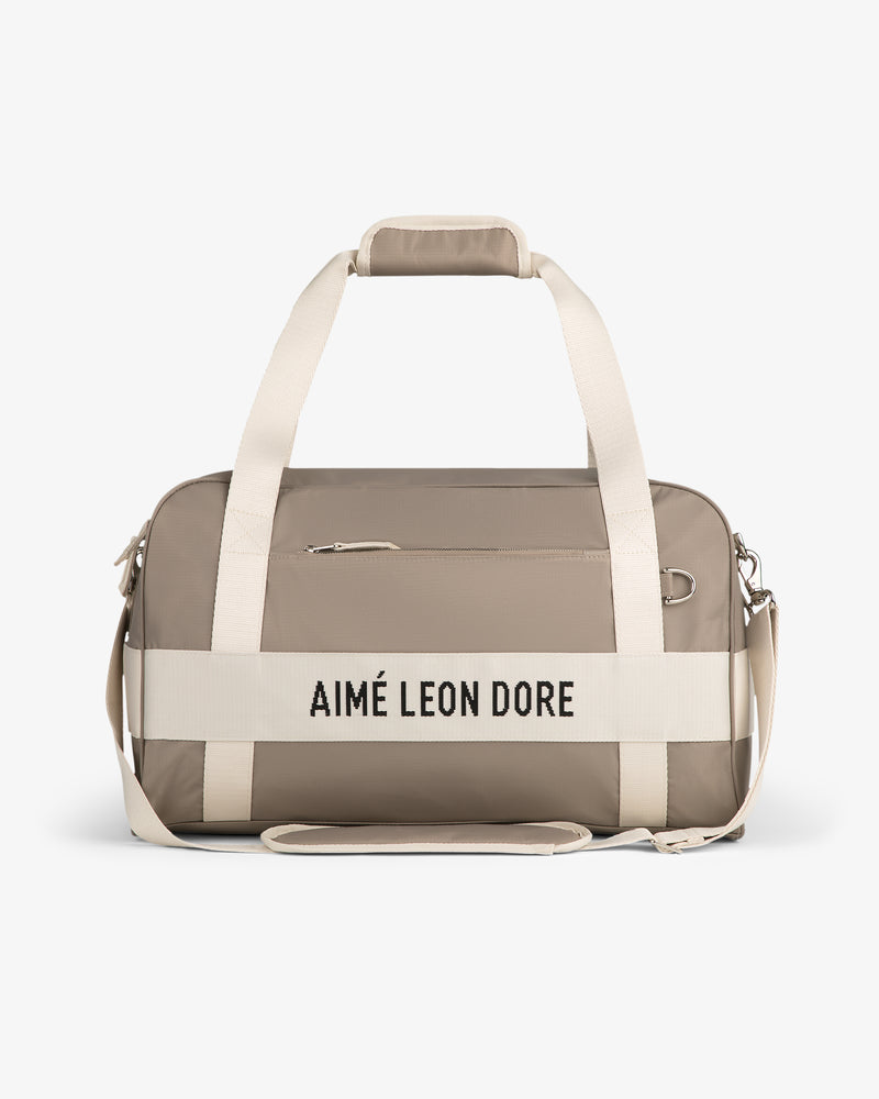 Nylon Duffle Bag in taupe with cream handles and strap, AIMÉ LEON DORE text on front.