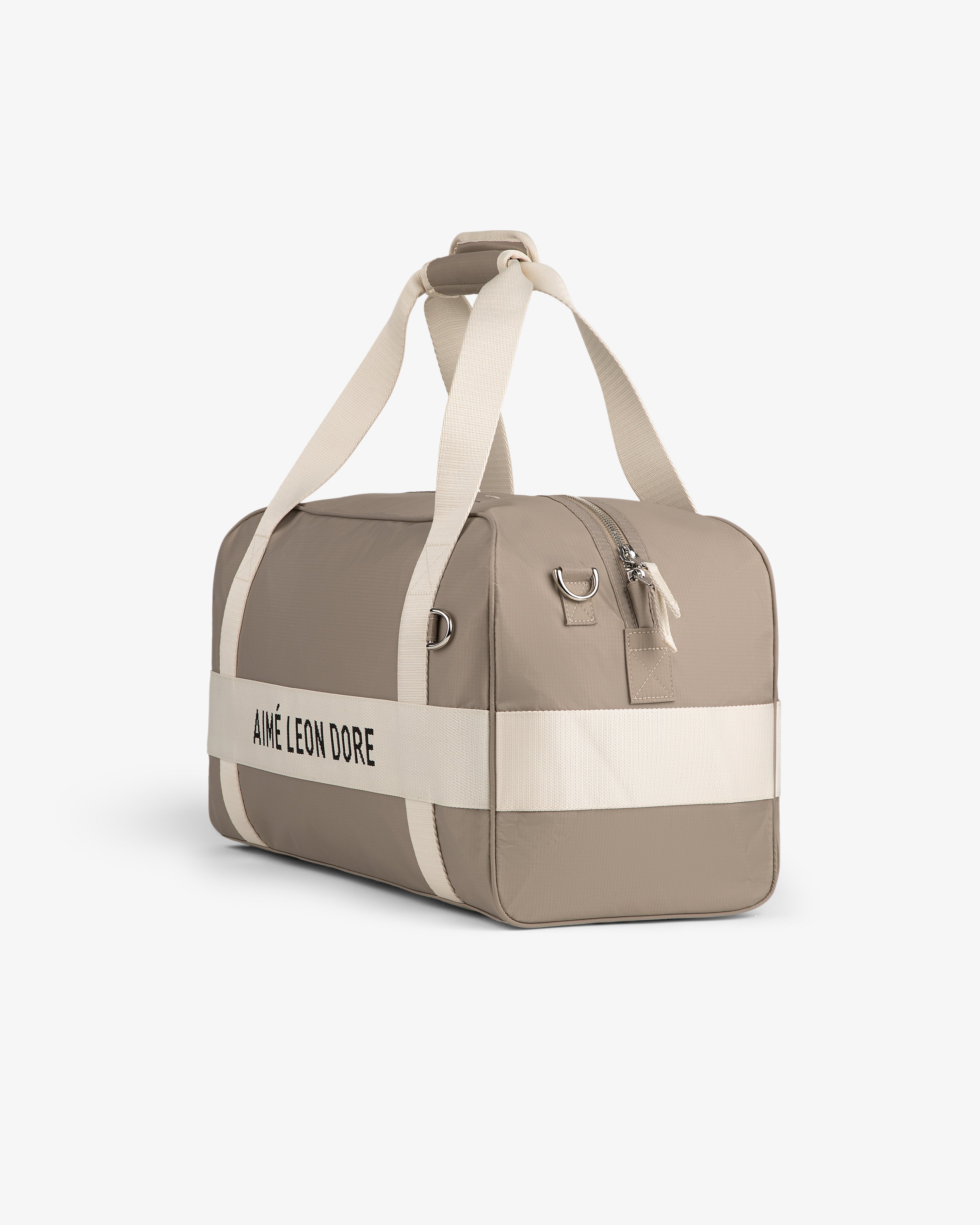Nylon Duffle Bag in beige with white straps and AIMÉ LEON DORE logo, displayed on a plain white background.