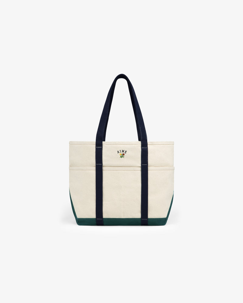 Large Crest Contrast Tote Bag: cream canvas with navy handles, green trim, and a small embroidered front design.