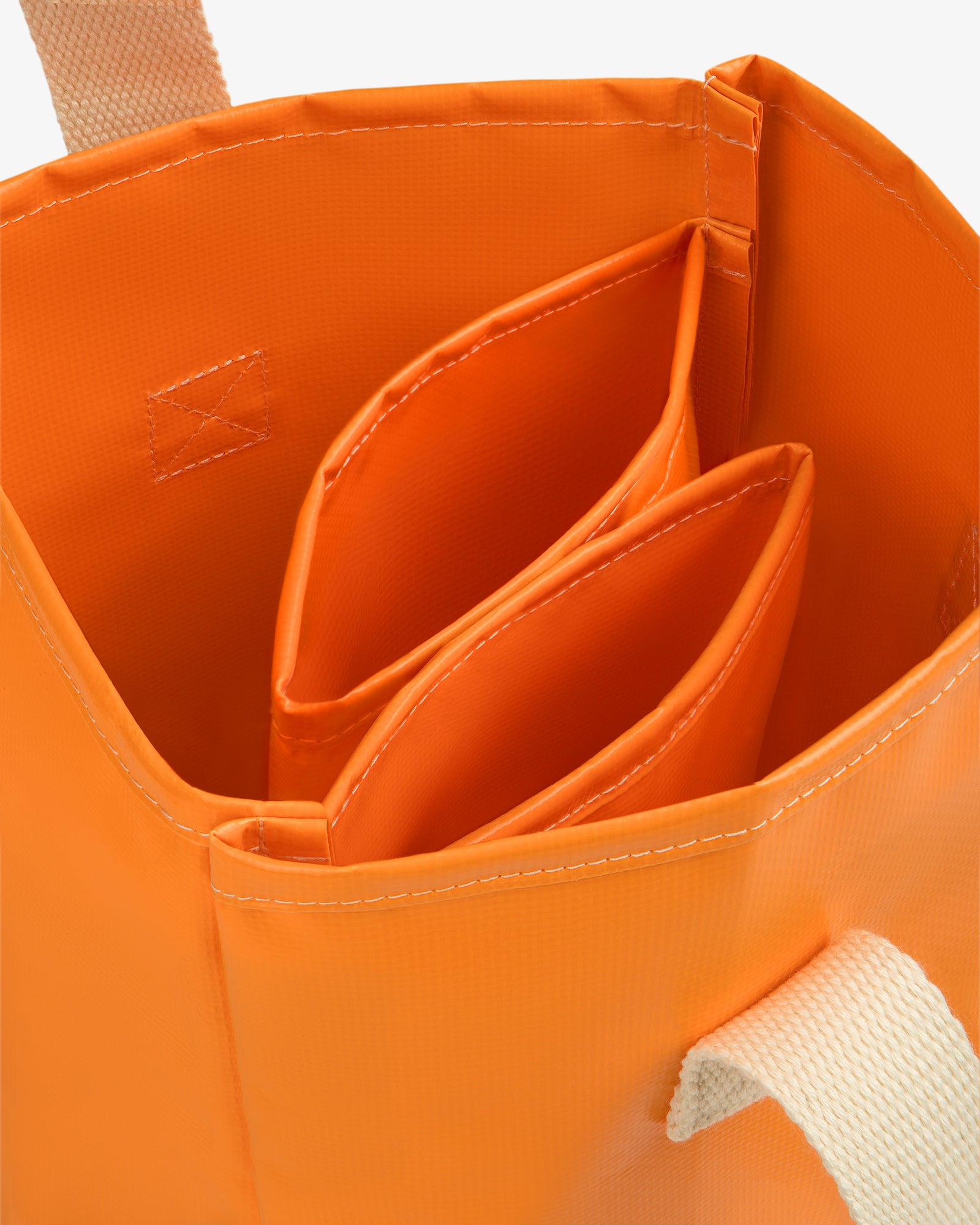Close-up of the Marina Bottle Tote, an orange bag with two inner dividers and beige carrying handles.