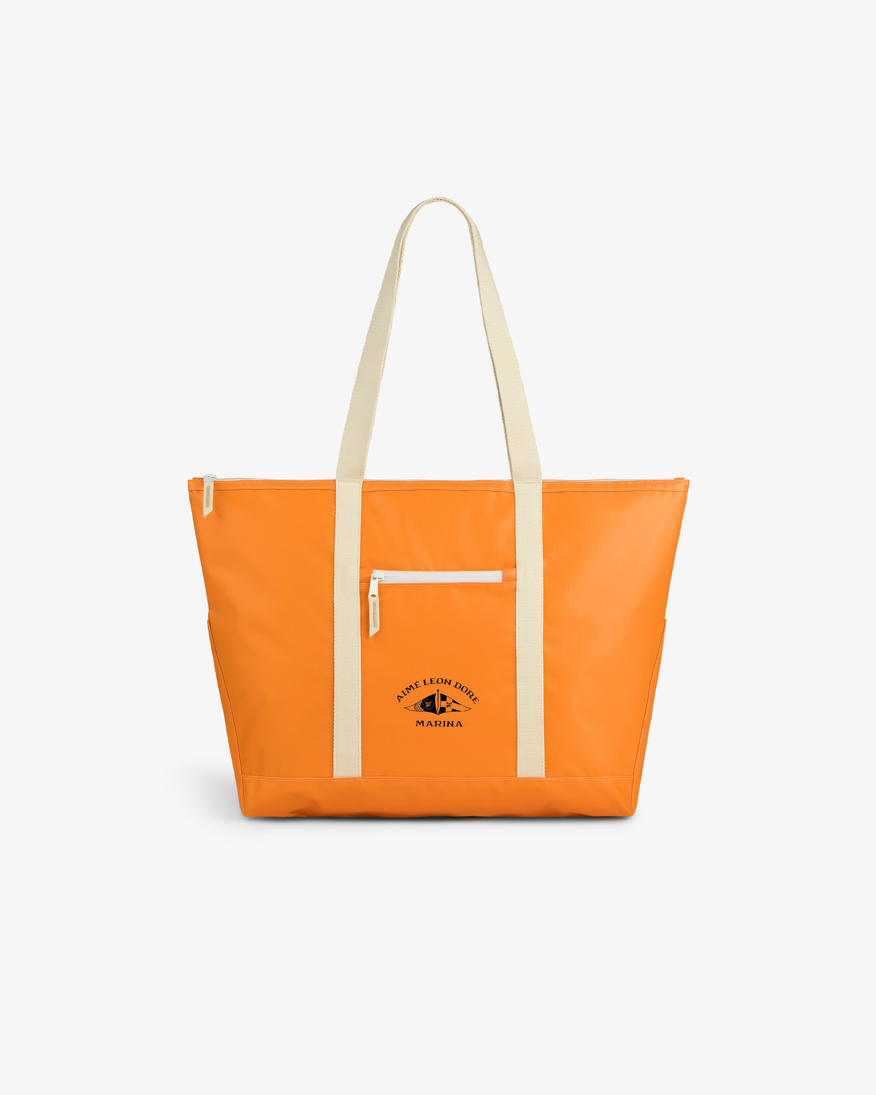 The Carryall Marina Tote features bright orange color, beige straps, a front zipper pocket, and a small black logo.