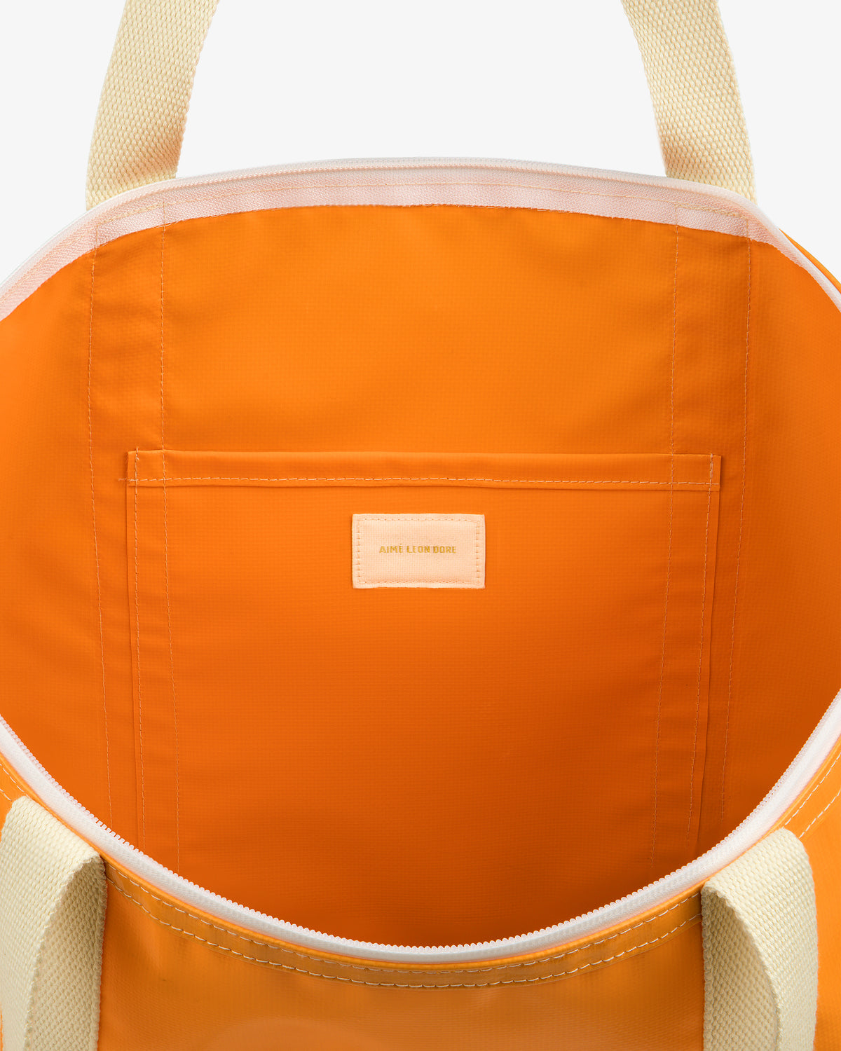 Carryall Marina Tote in orange with cream straps, inner pocket, and small AIME LEON DORE label.