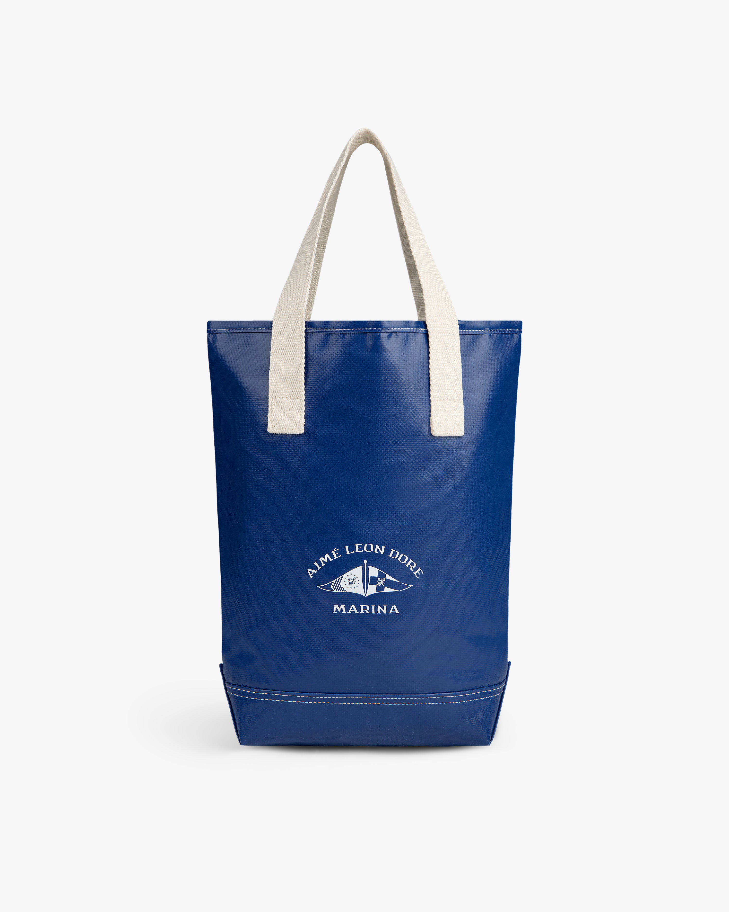 Marina Bottle Tote: Blue tote with white handles and an Aimé Leon Dore Marina fish logo on the front.