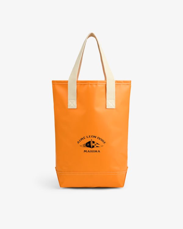Bright orange Marina Bottle Tote with beige handles and black Aime Leon Dore Marina logo on the front.