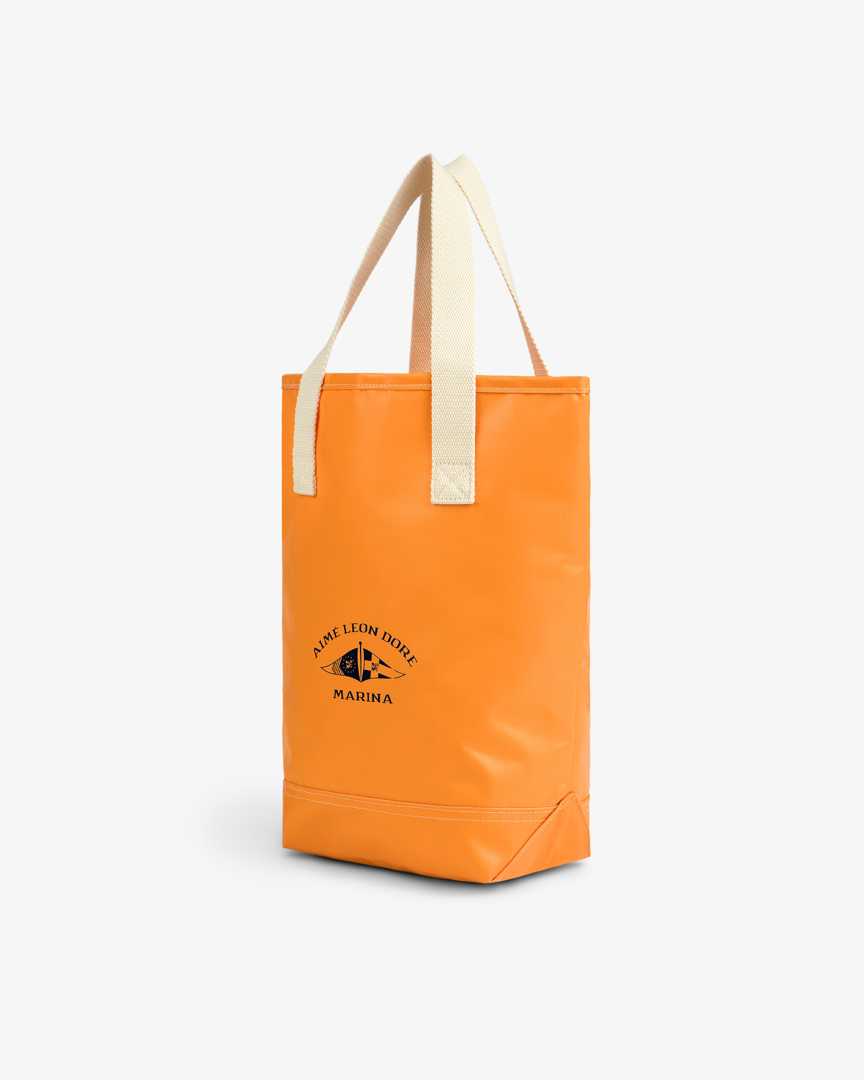 Marina Bottle Tote: orange bag with cream handles and a black Aime Leon Dore Marina logo on the front.