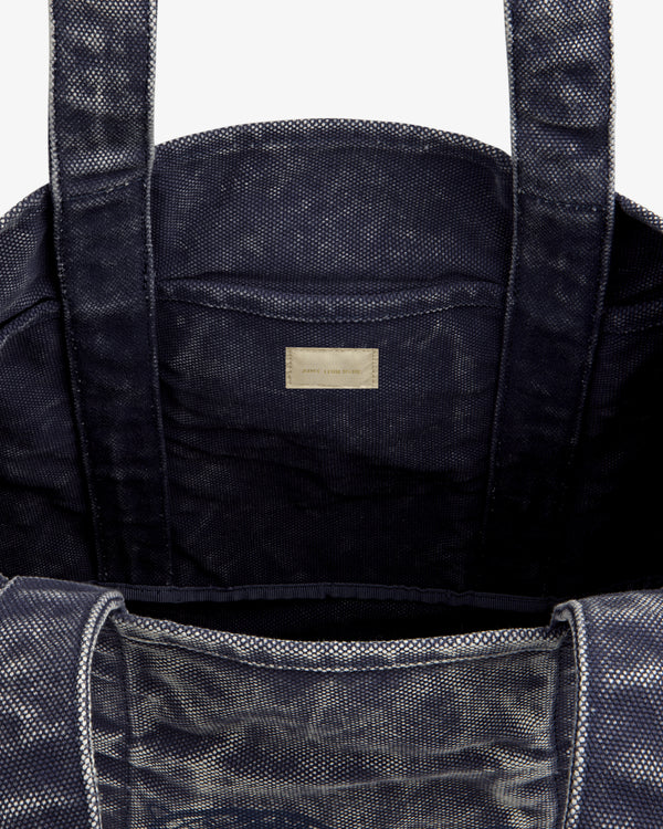 Close-up of the Sun Faded Large Unisphere Tote Bag's dark textured interior with two handles and a labeled inner pocket.