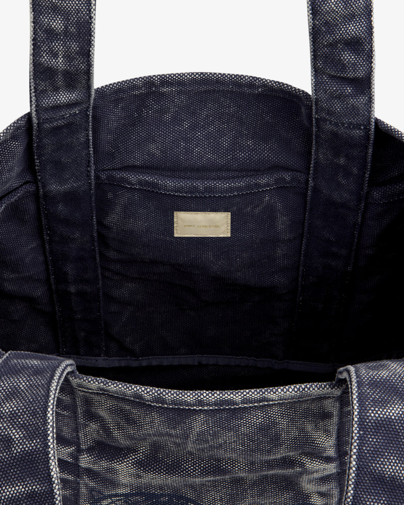 Close-up of the Sun Faded Large Unisphere Tote Bag's dark textured interior with two handles and a labeled inner pocket.