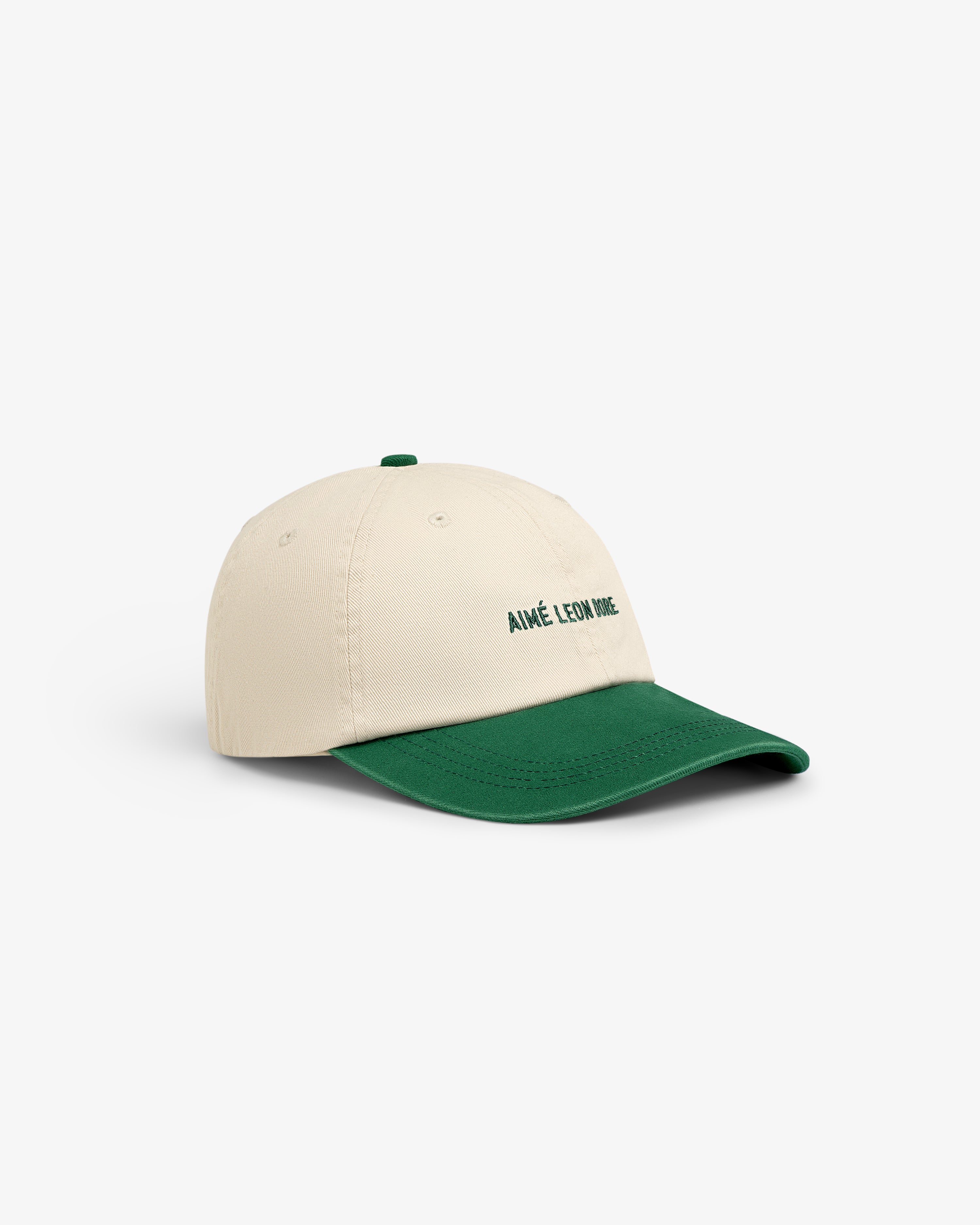 Washed Chino Hat in cream with green brim and AIMÉ LEON DORE text embroidered on the front.