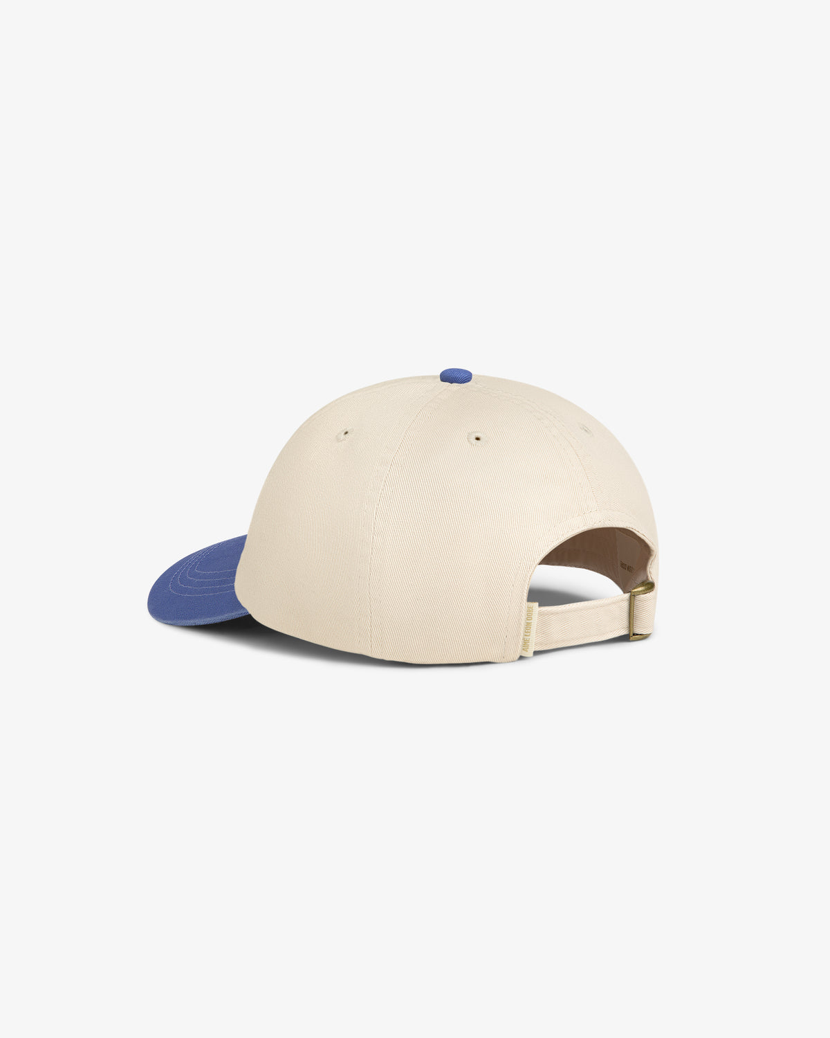 The Washed Chino Hat is beige with a blue brim and adjustable strap, shown from the back on a white background.