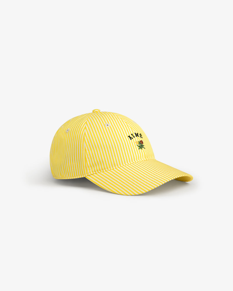 Striped Crest Logo Hat: Yellow-and-white stripes, small green palm tree, and L.A.M.B. logo embroidered on the front.