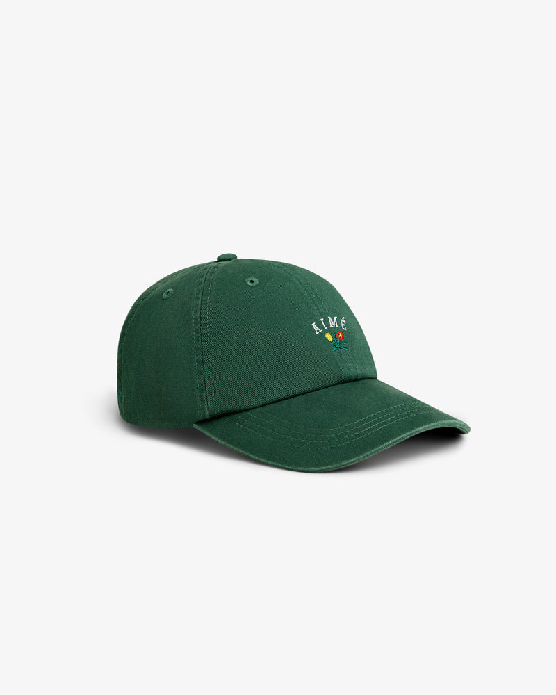Crest Logo Hat in dark green features a small colorful embroidered logo and text on the front, shown on white background.