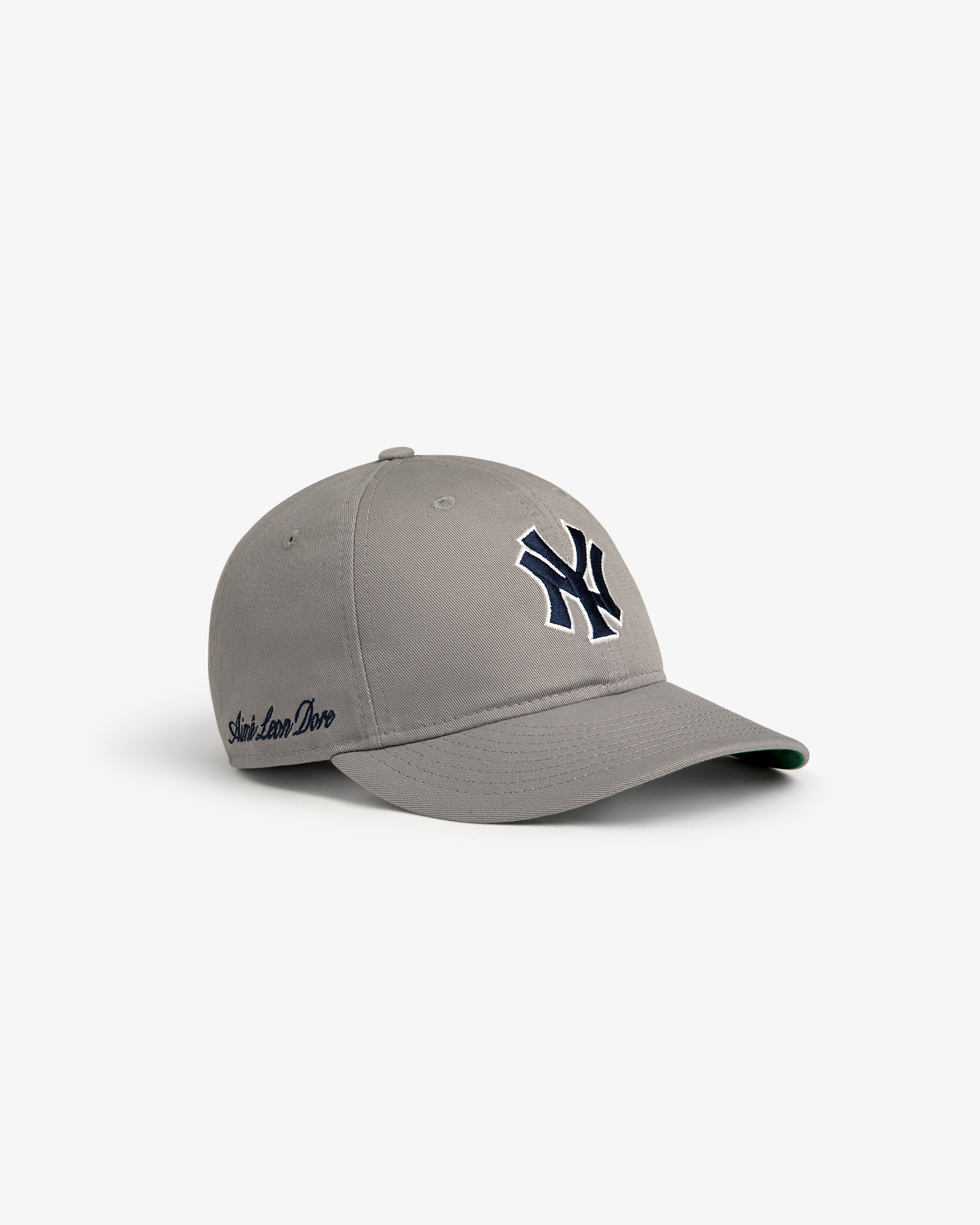 ALD / New Era Yankees Retro Fit Hat in gray with navy Yankees logo and “Slow Love Dove” embroidered on the side.