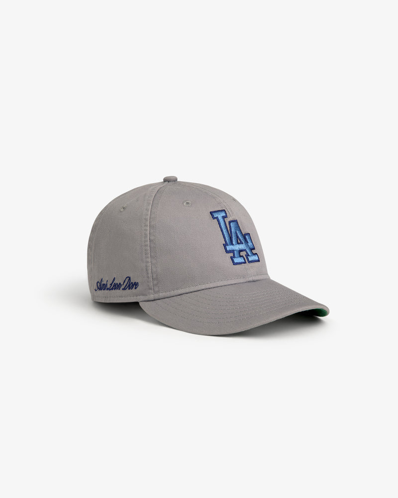 The ALD / New Era Dodgers Retro Fit Hat is gray with a blue LA logo and Aimé Leon Dore embroidered on the side.
