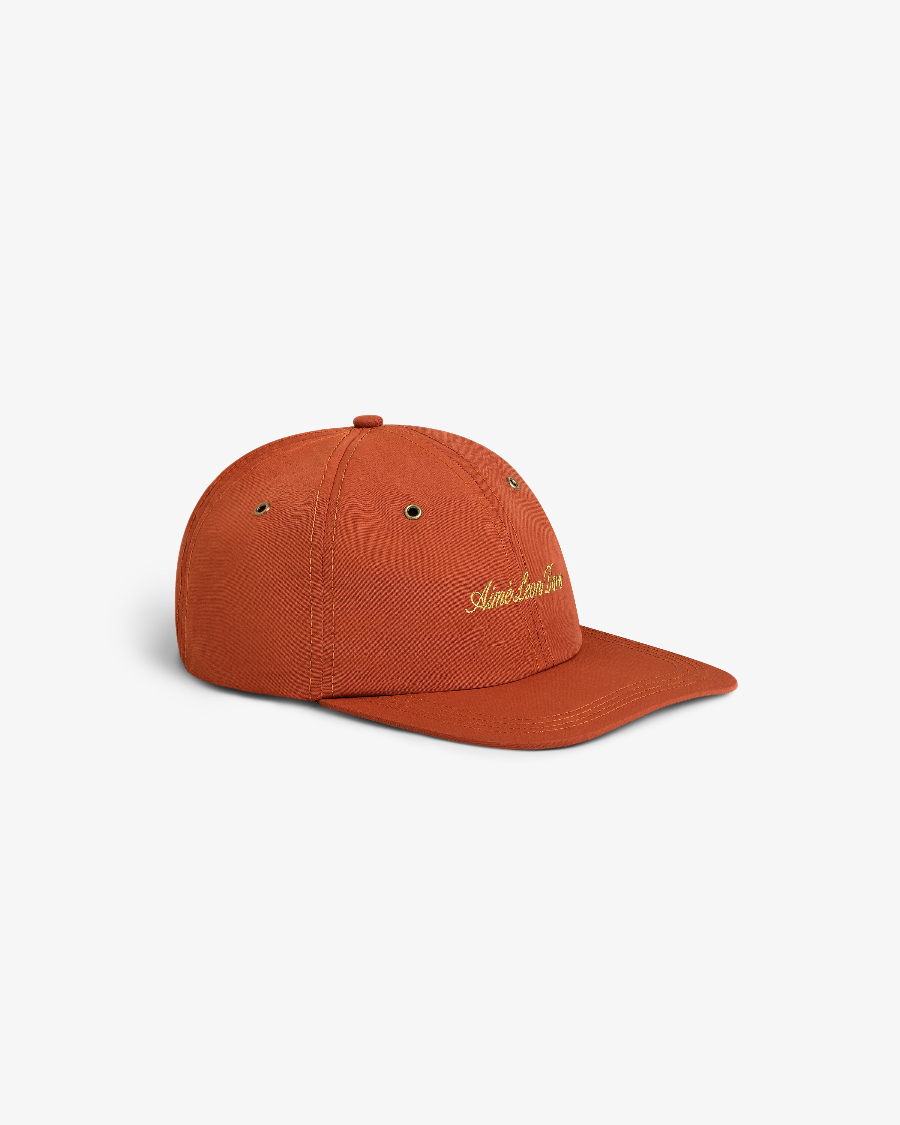 Script Sport Hat in burnt orange, featuring gold embroidered text, displayed on a plain white background.