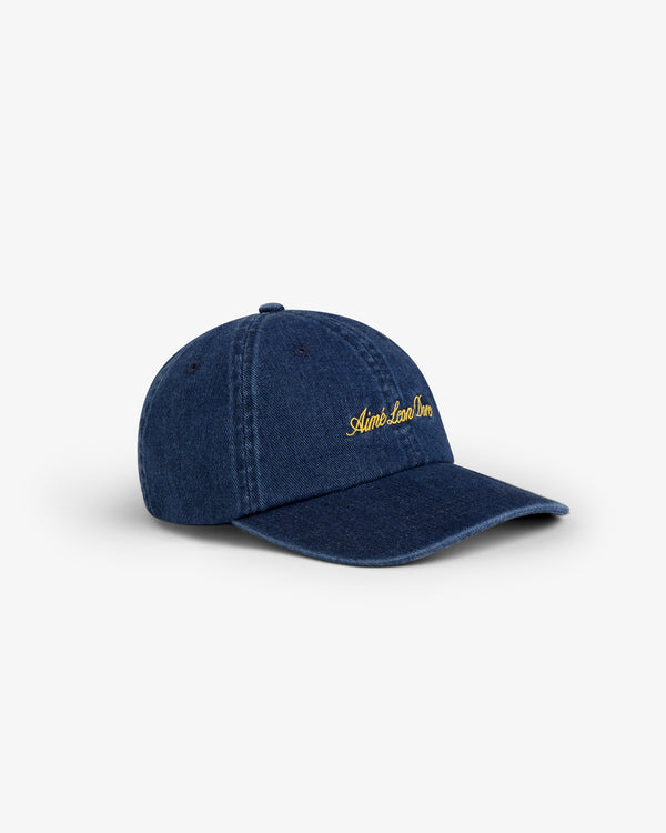 Denim Script Hat in dark blue with yellow "Aimé Leon Dore" embroidery, shown on a white background.
