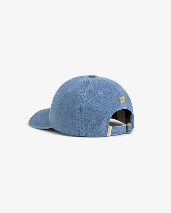 Denim Script Hat: Light blue denim cap with curved brim, adjustable strap, and small yellow logo above back opening.