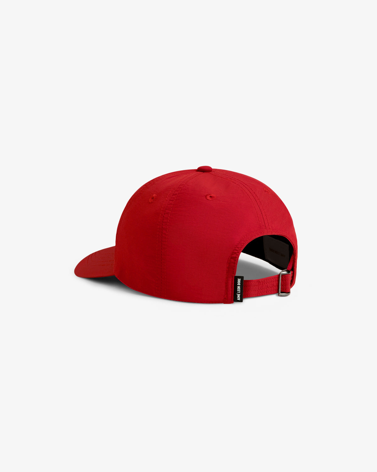 A red Nylon Crusher Hat viewed from the back, featuring an adjustable strap and a small black side tag.