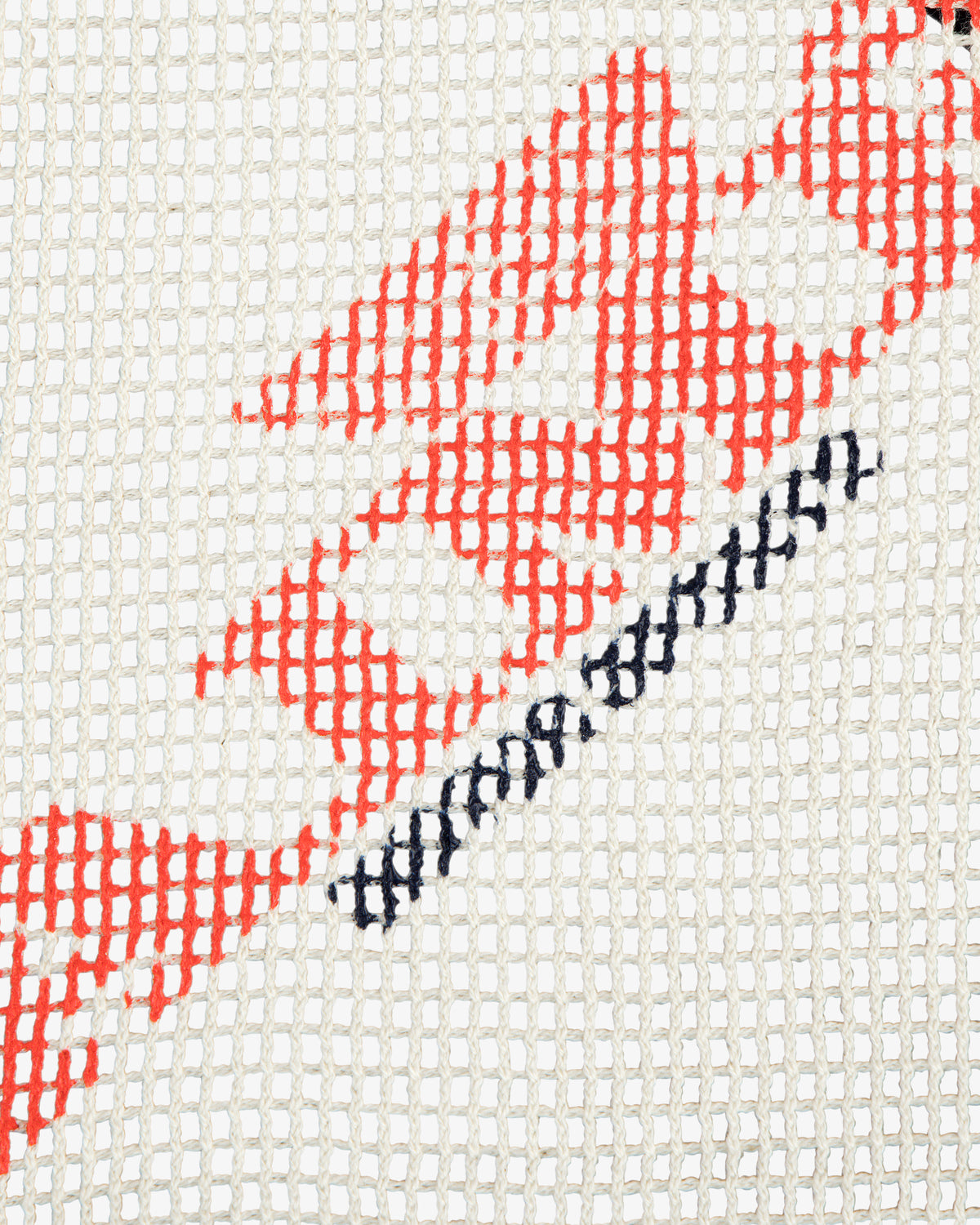 Close-up of the Aimé Painters Hat in a red and black geometric embroidery on white mesh fabric.