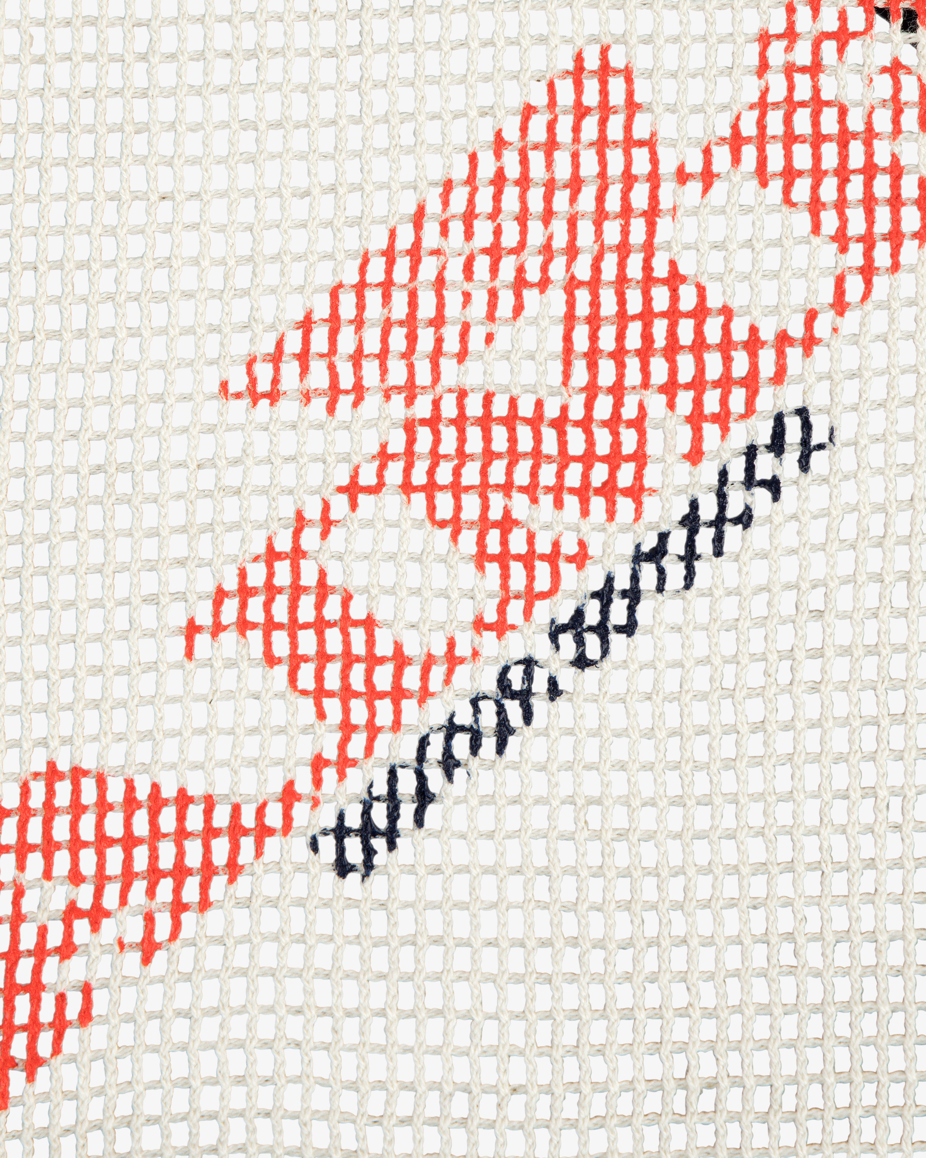 Close-up of the Aimé Painters Hat in a red and black geometric embroidery on white mesh fabric.